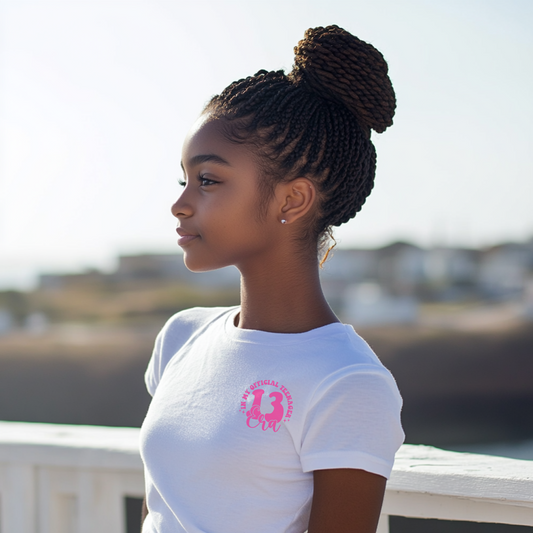 Teen girl wearing ‘In My Official Teenager Era’ birthday t-shirt, celebrating 13th birthday outdoors, there is a in my official teenager era shirt with a 13 on the front left pocket area

